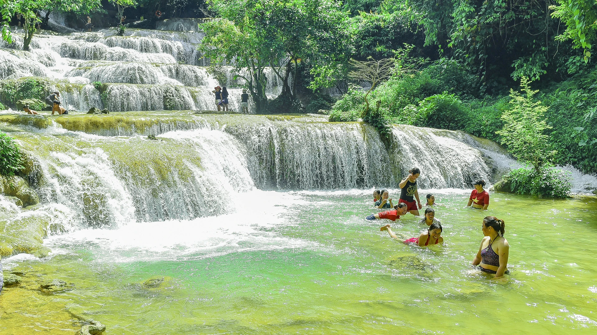 Đứng dưới chân thác, du khách dễ dàng cảm nhận hơi nước mát lạnh lan tỏa, xen lẫn tiếng ào ạt của dòng thác đổ xuống tựa bản hòa tấu giữa thiên nhiên. Hai bên bờ là những gốc cổ thụ rêu phong, tỏa bóng xanh mát, tạo nên khung cảnh vừa hùng vĩ, vừa thơ mộng.