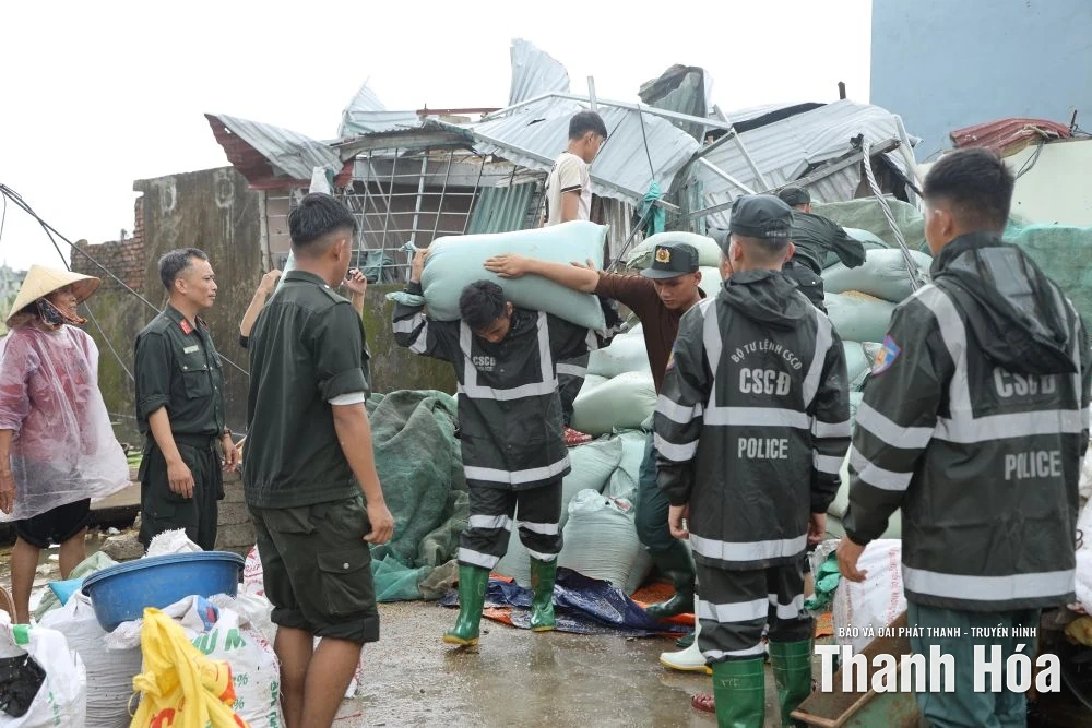 Chiến sĩ Cảnh sát cơ động hỗ trợ người dân xã Hoằng Phú khắc phục thiệt hại sau trận lốc xoáy