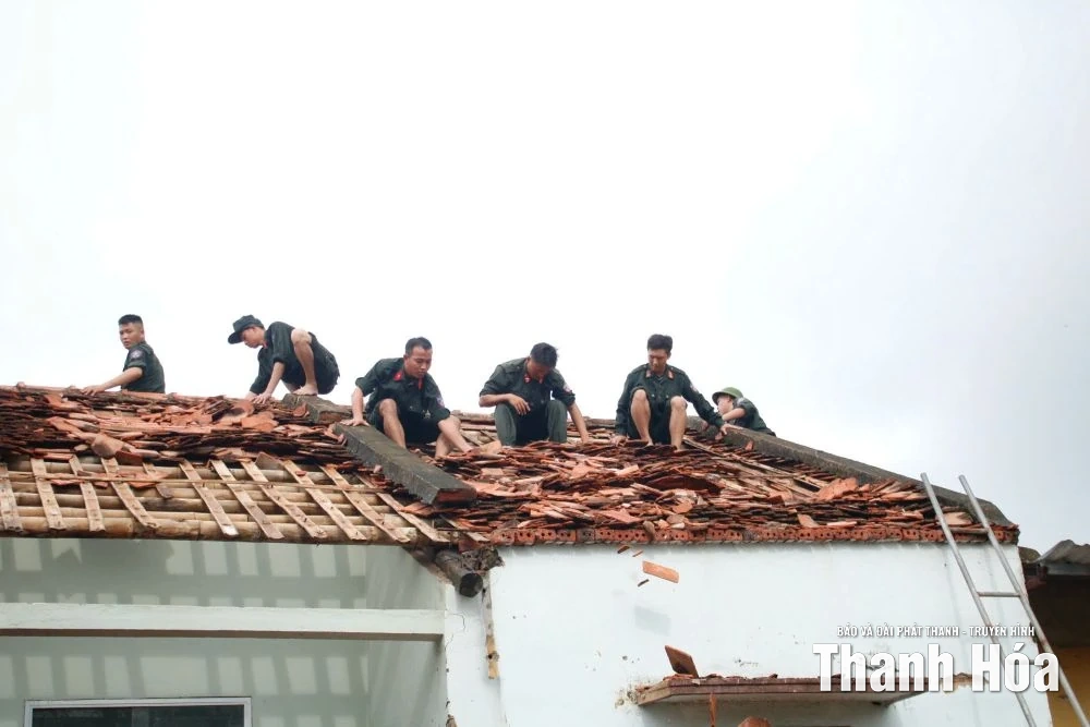 Chiến sĩ Cảnh sát cơ động hỗ trợ người dân xã Hoằng Phú khắc phục thiệt hại sau trận lốc xoáy