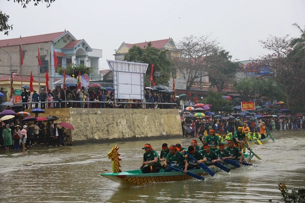 Người dân đội mưa xem Lễ hội đua thuyền truyền thống xã Trung Chính