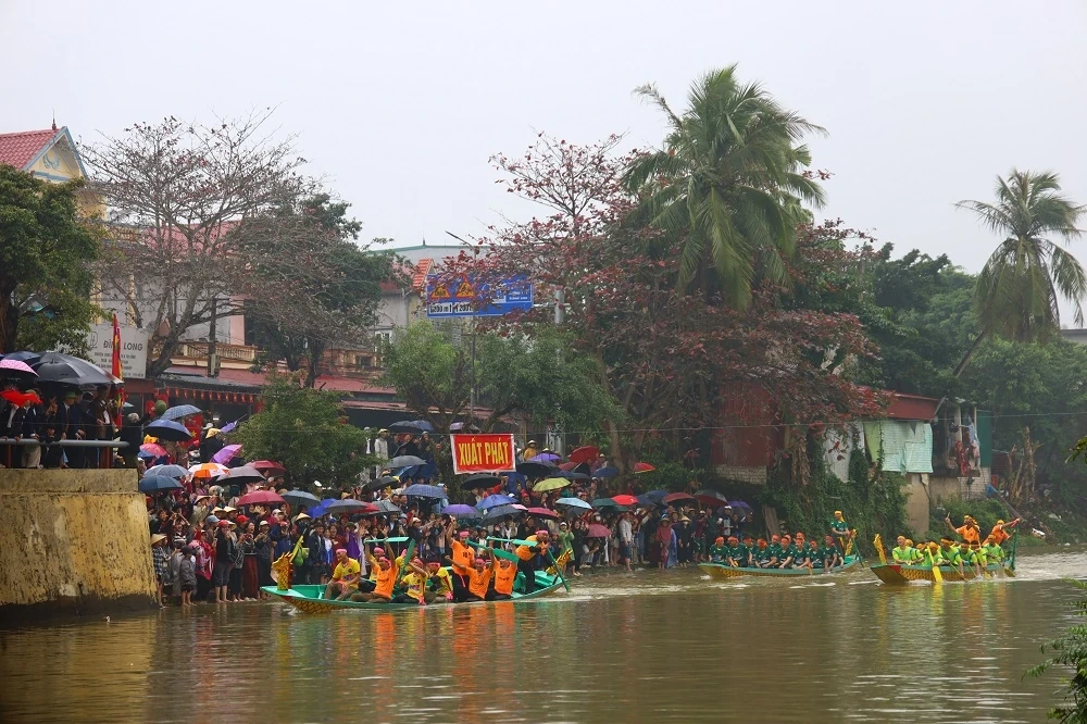 Người dân đội mưa xem Lễ hội đua thuyền truyền thống xã Trung Chính