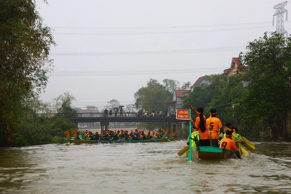 Người dân đội mưa xem Lễ hội đua thuyền truyền thống xã Trung Chính