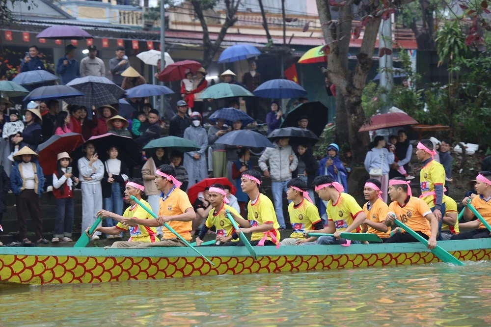 Người dân đội mưa xem Lễ hội đua thuyền truyền thống xã Trung Chính