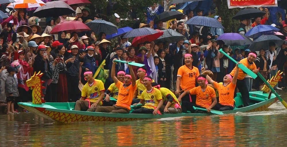 Người dân đội mưa xem Lễ hội đua thuyền truyền thống xã Trung Chính