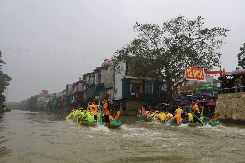 Người dân đội mưa xem Lễ hội đua thuyền truyền thống xã Trung Chính