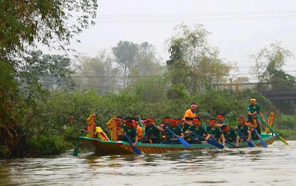 Người dân đội mưa xem Lễ hội đua thuyền truyền thống xã Trung Chính