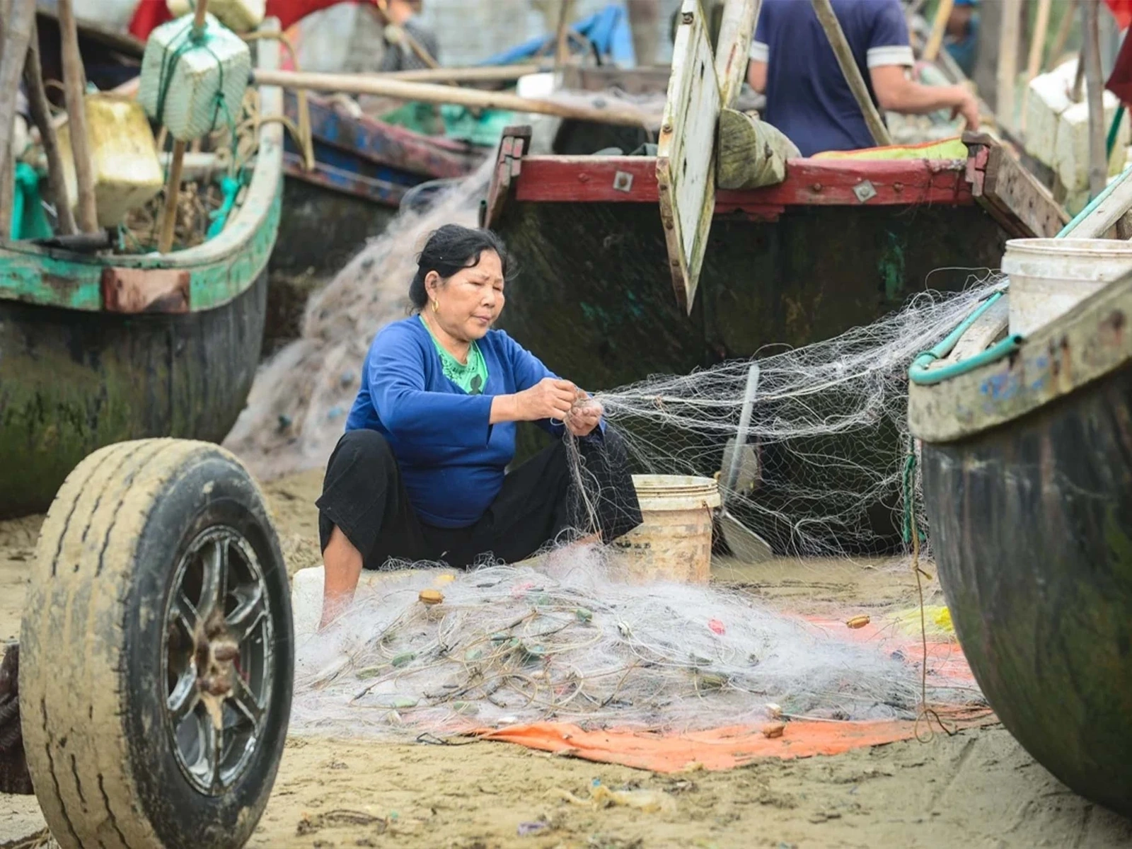 Sau buổi đánh bắt vất vả, các bà, các mẹ tỉ mỉ vá lại từng mắt lưới để chuẩn bị cho buổi đánh bắt tiếp theo của những người đàn ông trong nhà.