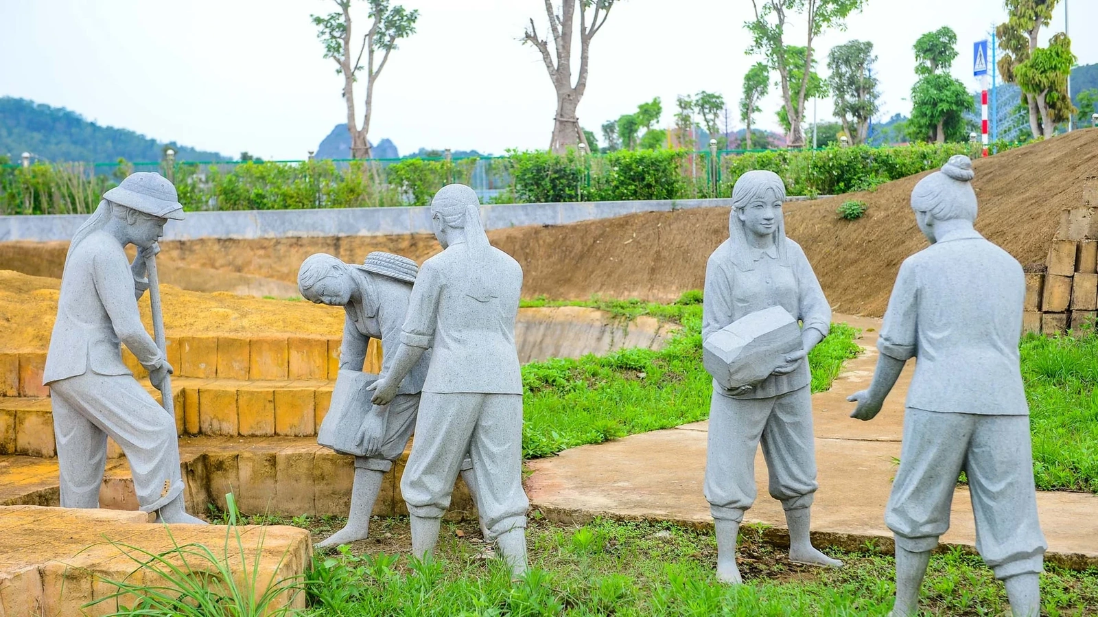 Giữa không gian ấy, các cụm tượng đá khắc họa hình ảnh giáo viên, học sinh đang lao động đắp đê - những khoảnh khắc bình dị bị cắt ngang bởi chiến tranh - tạo nên một trường đoạn thị giác ám ảnh và giàu cảm xúc.