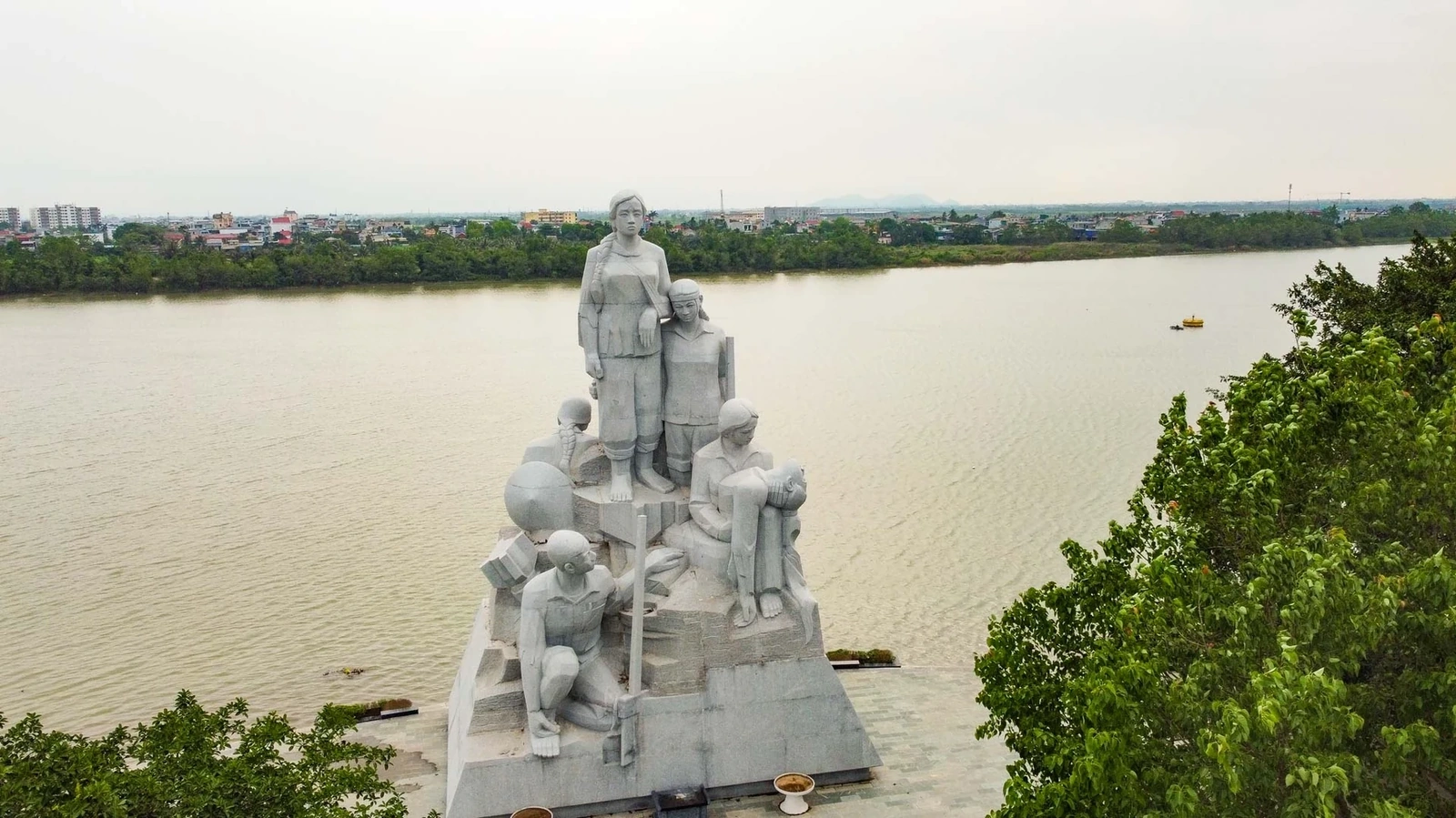 Tượng  gợi lại khoảnh khắc giáo viên và học sinh đang đắp đê thì bất ngờ bom đạn ập xuống. Ngôn ngữ tạo hình mang đậm phong cách thập niên 1970, từ trang phục đến thần thái, tái hiện rõ nét một thế hệ trẻ trung, giàu lý tưởng và lòng kiên trung.