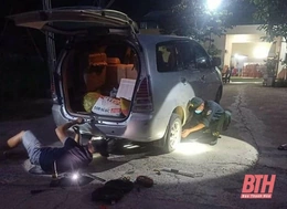 Cán bộ chốt kiểm soát dịch COVID-19 vá xe ô tô trong đêm cho người đi đường