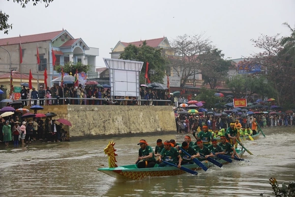 Người dân đội mưa xem Lễ hội đua thuyền truyền thống xã Trung Chính